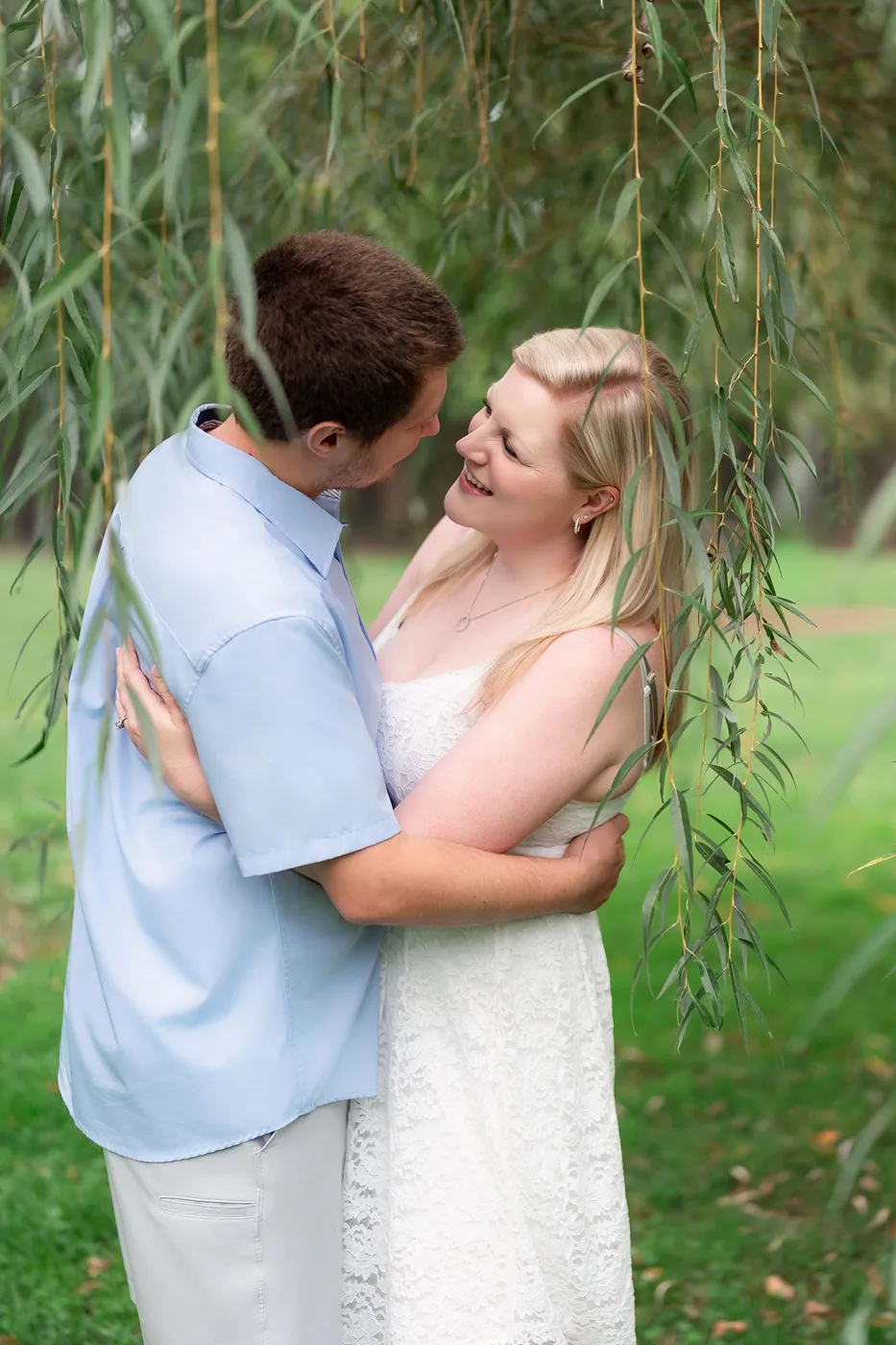 Kaitlyn and Nicholas embracing beneath the willow branches
